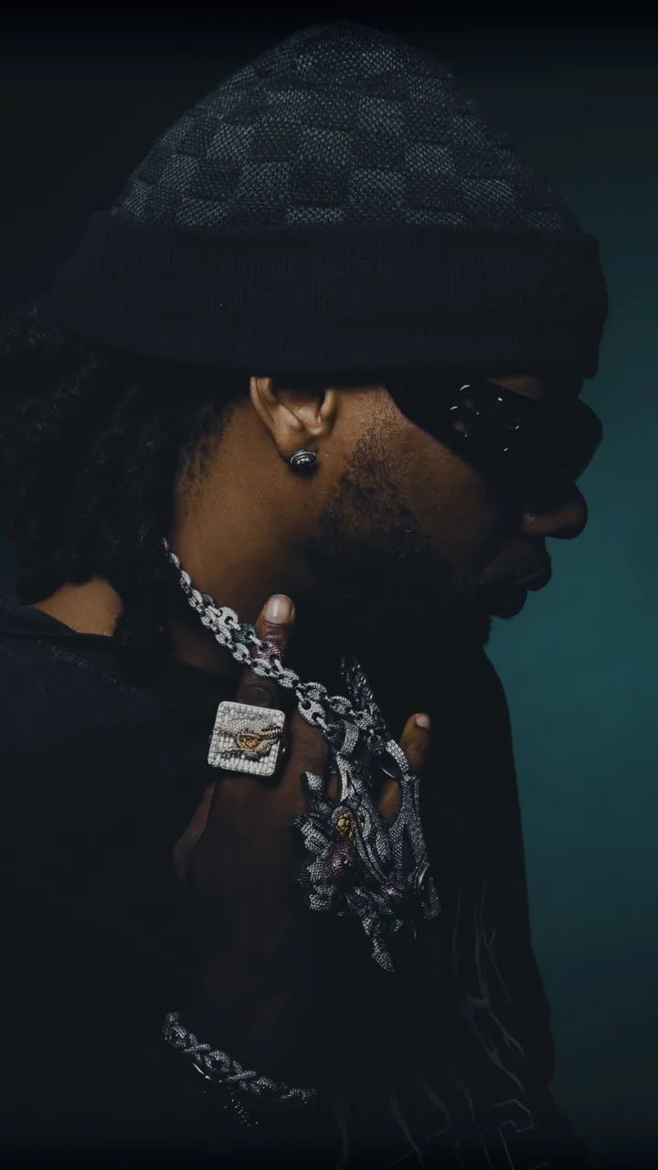 Profile portrait wearing an iced-out chain, pendant and ring