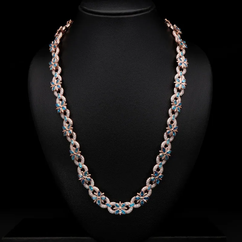 Stone-set link chain with blue accents on a black bust