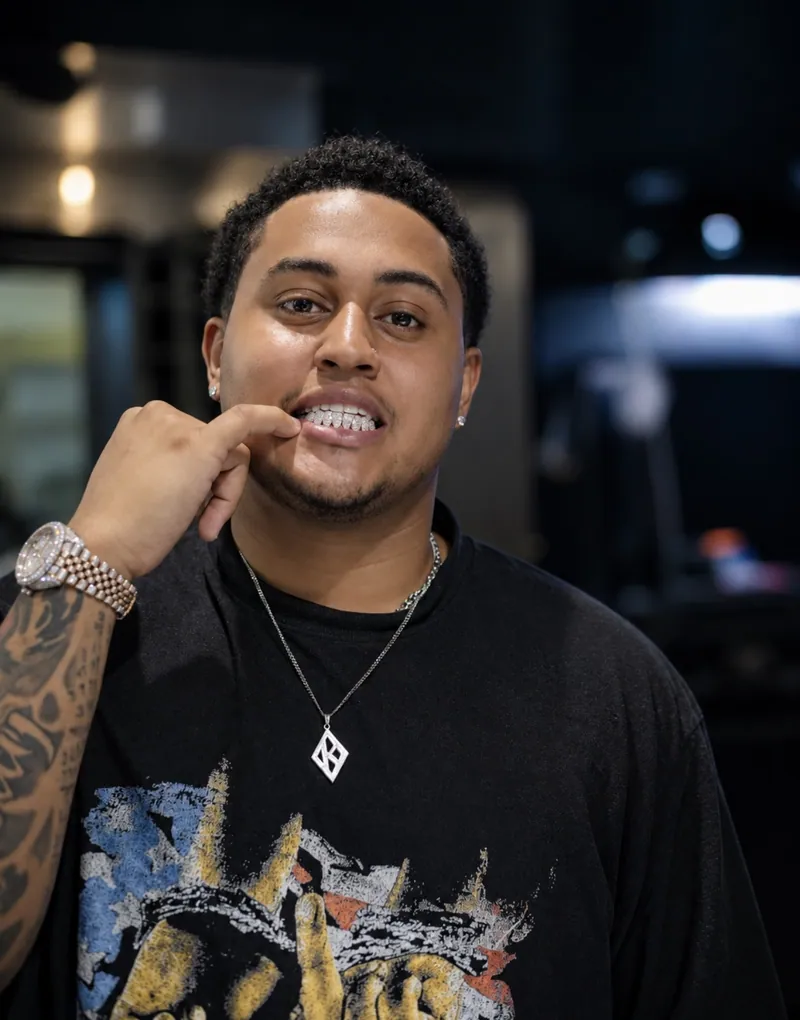 A smiling client pointing to his custom grillz