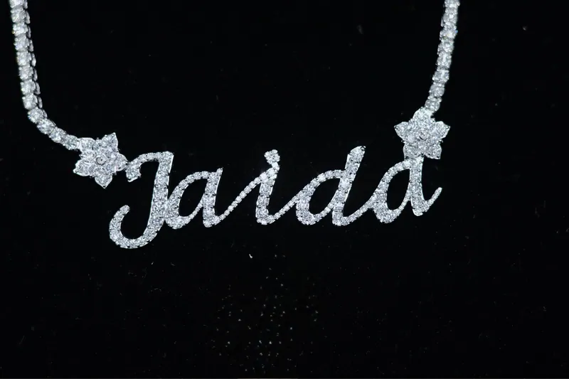 Stone-set Jaida script nameplate with flower accents on a tennis chain