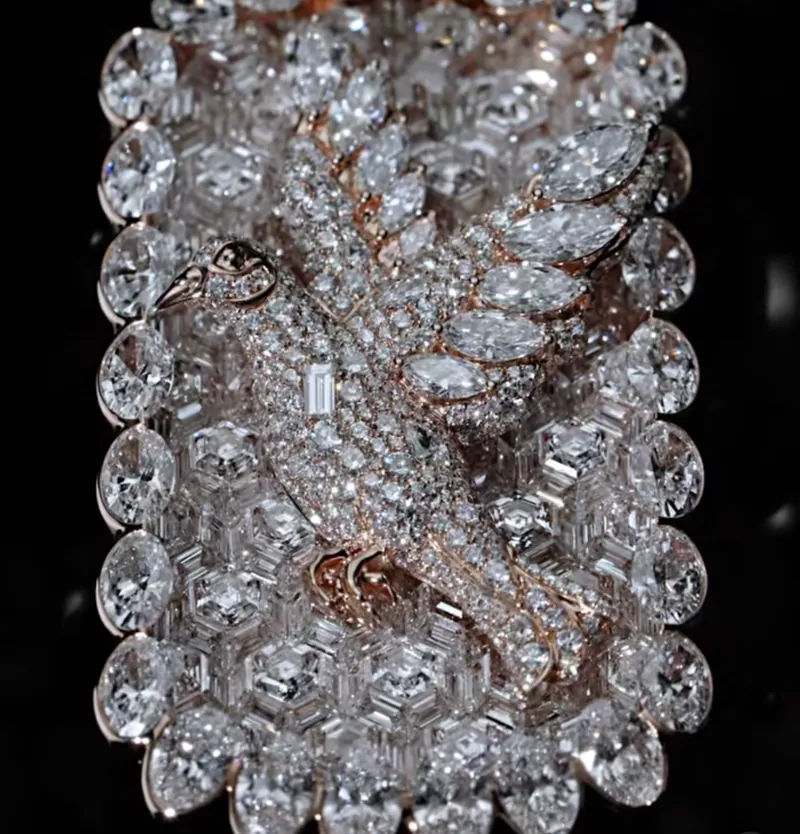 Close-up of a rose-tone winged figure framed by large round stones